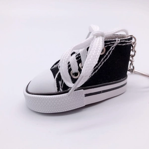 Mini black canvas sneaker keychain with white laces and durable metal keyring attachment