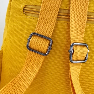 Detail of adjustable metal buckles on the yellow canvas shoulder straps of the toddler backpack
