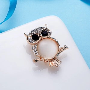 Broche chouette tendance avec base en métal doré, pierre opale blanche et strass brillants