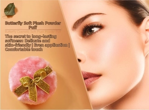 Detailed shot of pink plush powder puff with golden glitter bow for makeup application