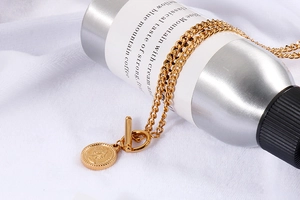Macro view of gold chain necklace with queen coin pendant and vintage OT toggle clasp