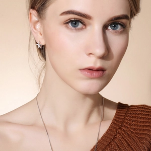Minimalist 925 sterling silver starfish hoop earrings worn by a model in soft lighting