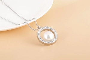 Gros plan du collier en acier titane argenté avec cercle serti de diamants et perle