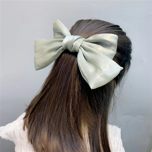 Macro detail of high-quality light green organza bow hair clip for elegant styling