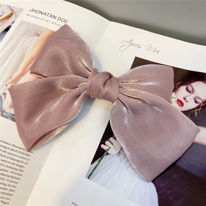 Detail of a large organza bow hair clip in dusty rose with a pearlescent silk texture
