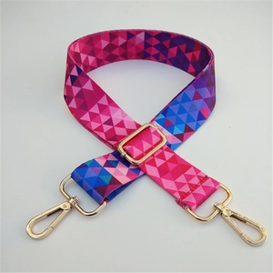 Close-up of a colorful geometric pattern bag strap with gold metal lobster clasps