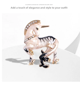 Close-up of vintage unicorn brooch with champagne enamel and white zircon details