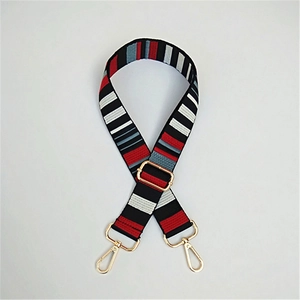 Detail of adjustable ethnic striped wide shoulder strap with golden metal swivel hooks