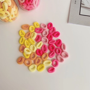 Macro shot of colorful seamless rainbow gradient hair ties scattered on white surface