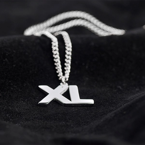 Polished silver titanium steel necklace featuring large XL letter pendant on black velvet