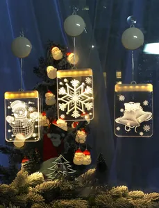 Close-up of 3D snowman and bell LED suction cup lights with warm festive glow