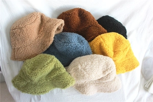 Detailed pile of thick lamb wool bucket hats in multiple colors for winter warmth
