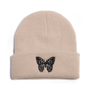 Close-up of butterfly embroidery detail on beige winter knit beanie cap