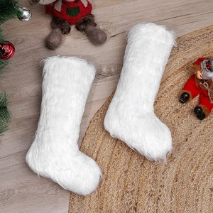White plush Christmas stockings with faux fur trim displayed on rustic wooden floor background