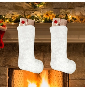Detail of white plush Christmas stockings with burlap trim and red button ornaments