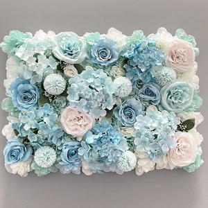 Close-up of blue and white silk roses with hydrangeas on a floral wall backdrop