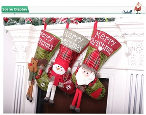 Set di calze natalizie appese con Babbo Natale e pupazzo di neve su un camino bianco