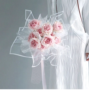 Detail of waterproof transparent OPP flower wrapping paper with pink roses in hand