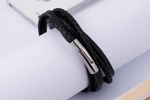 Detail of multi-layer black leather woven bracelet with silver stainless steel clasp