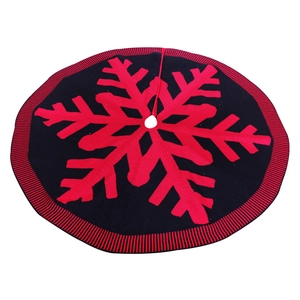 Knitted red and black Christmas tree skirt with large snowflake pattern and striped border