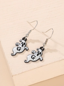 Close-up of black and white ghost earrings with letter G engraving and silver hooks