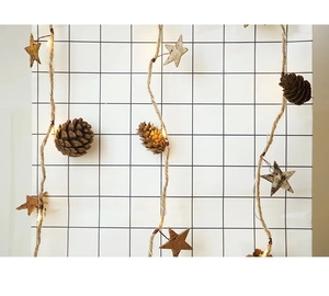 Detail of rustic hemp rope LED fairy lights with pine cones and wooden stars ornaments