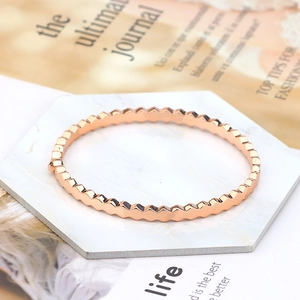 Detailed view of rose gold geometric honeycomb bracelet on a white marble tray