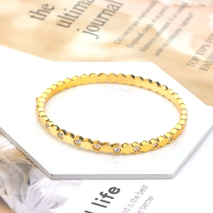 Detailed view of gold hexagon honeycomb bracelet with inlaid round white cubic zirconia