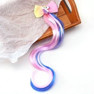 Detail of colorful bow hair clip with unicorn ornament and long gradient wavy hairpiece