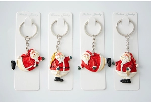 Detailed view of four festive Christmas Santa Claus resin keychains on gift cards