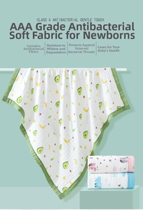 Detail of soft cotton gauze baby blanket with cute avocado and banana cartoon patterns