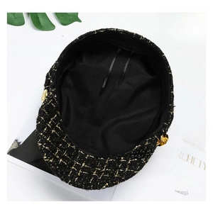 Macro shot of tweed baker boy hat with gold buckle and adjustable inner ribbon