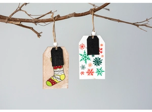 Detail of Christmas wooden tags with Santa and snowman patterns hanging on a branch