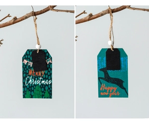 Close-up of wooden Christmas tree and reindeer gift tags with twine and white beads