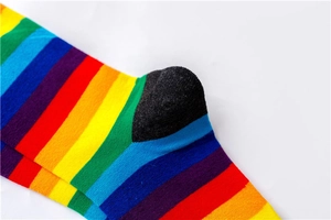 Close-up of vibrant rainbow stripes and black heel on soft cotton knit crew socks