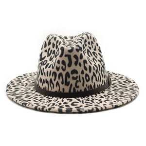 Detail of leopard print fedora hat featuring brown leather band and metal buckle accent