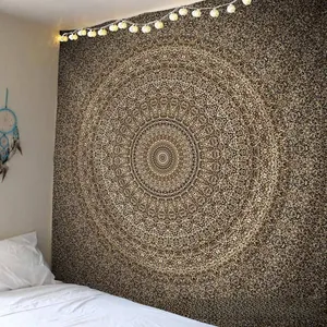 Détail de la tapisserie Mandala aux motifs noirs et dorés sur le mur d'une chambre
