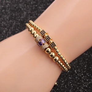 Gold beaded bracelet set with purple zircon stones and black cubic micro-inlay on wrist