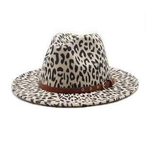 Detail of leopard print fedora hat featuring a brown leather belt with gold buckle
