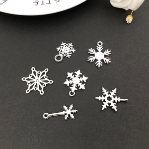 Detailed view of assorted silver snowflake alloy charms for DIY Christmas bracelets