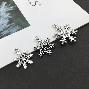 Macro detail of antique silver snowflake charms for DIY jewelry making and bracelets