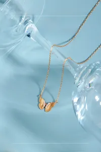 Détail du pendentif papillon doré avec petits diamants et textures des ailes
