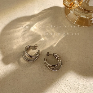 Macro shot of silver triple-layered spiral earrings with glossy metallic finish