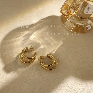 Triple layer gold hoop earrings with polished metallic finish and elegant layered design