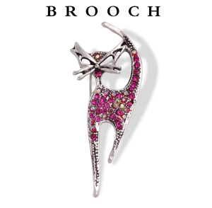 Macro detail of retro cat brooch featuring pink rhinestones on a silver metal setting