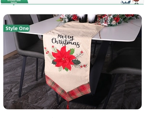 Detail of Christmas table runner with Merry Christmas print and red floral accents
