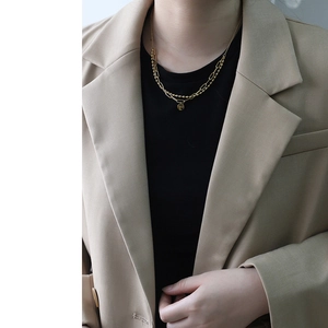 Close-up of double-layered 18K gold-plated beaded necklace with round coin pendant