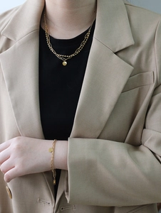 Close-up of double-layered 18K gold-plated titanium necklace and bracelet set on a model