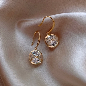 Elegant gold drop earrings with large round crystal and cubic zirconia on silk background