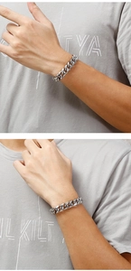 Detailed close-up of a men's silver stainless steel Cuban link bracelet worn on the wrist